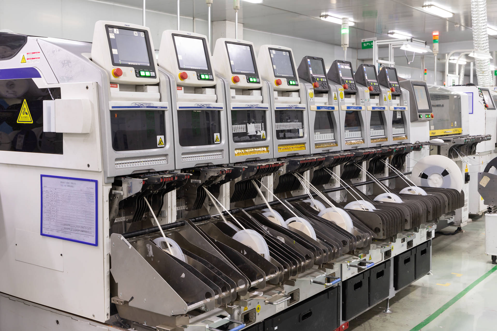 Automated SMT production line with pick-and-place machines, component reels and operator interfaces